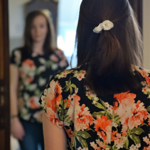 woman with chronic illness looks in the mirror and is invisible